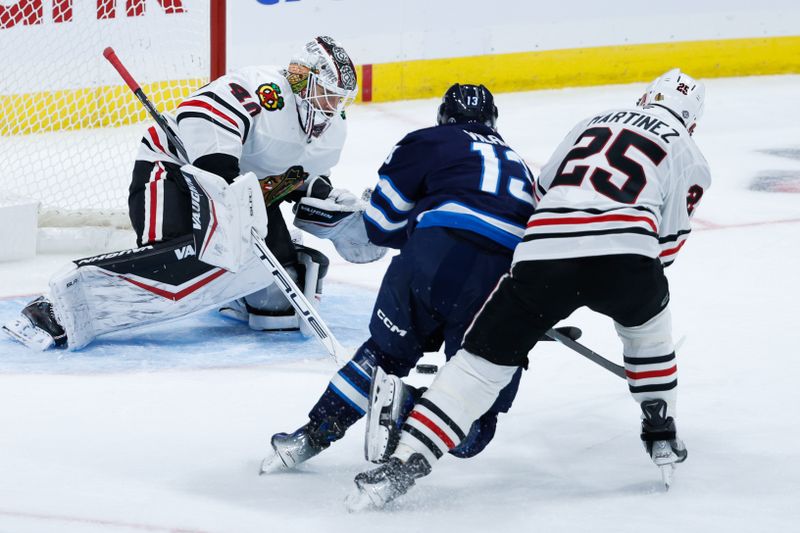 Oct 11, 2024; Winnipeg, Manitoba, CAN;  Chicago Blackhawks goalie Arvid Soderblom (40) makes a save on a shot by Winnipeg Jets forward Gabriel Vilardi (13) during the third period at Canada Life Centre. Mandatory Credit: Terrence Lee-Imagn Images