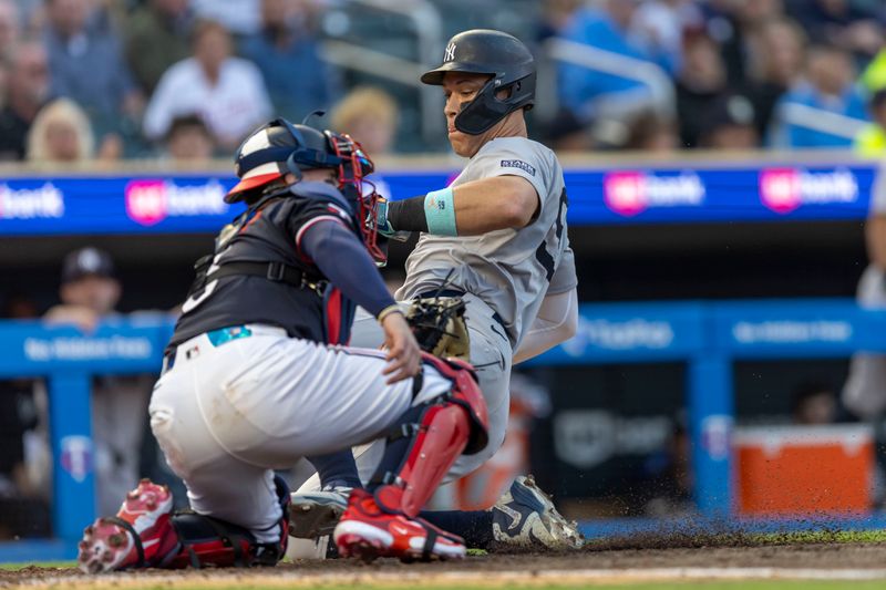 May 14, 2024; Minneapolis, Minnesota, USA; New York Yankees center fielder Aaron Judge (99) slides safely into home plate for a run before Minnesota Twins catcher Christian Vázquez (8) can make a tag in the fourth inning at Target Field. Mandatory Credit: Jesse Johnson-USA TODAY Sports