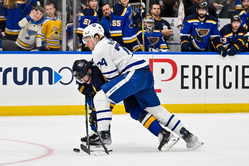 Feb 19, 2024; St. Louis, Missouri, USA;  St. Louis Blues defenseman Torey Krug (47) and Toronto Maple Leafs center Bobby McMann (74) battle for the puck during the third period at Enterprise Center. Mandatory Credit: Jeff Curry-USA TODAY Sports