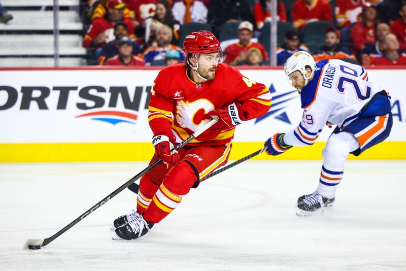 Nov 3, 2024; Calgary, Alberta, CAN; Calgary Flames defenseman Rasmus Andersson (4) skates with the puck against the Edmonton Oilers during the third period at Scotiabank Saddledome. Mandatory Credit: Sergei Belski-Imagn Images
