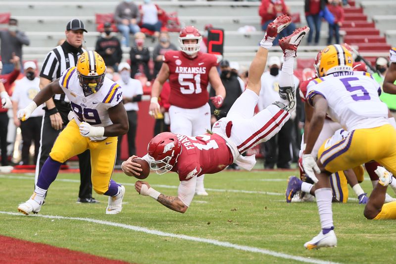 Nov 21, 2020; Fayetteville, Arkansas, USA;  Arkansas Razorbacks quarterback Feleipe Franks (13) dives for a touchdown as LSU Tigers defensive lineman Jaquelin Roy (99) defends during the second quarter at Donald W. Reynolds Razorback Stadium. Mandatory Credit: Nelson Chenault-USA TODAY Sports