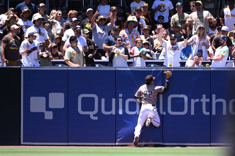 Jun 25, 2023; San Diego, California, USA; San Diego Padres left fielder Juan Soto (22) collides with the outfield wall after making a catch on a ball hit by Washington Nationals first baseman Dominic Smith (not pictured) during the second inning at Petco Park. Mandatory Credit: Orlando Ramirez-USA TODAY Sports