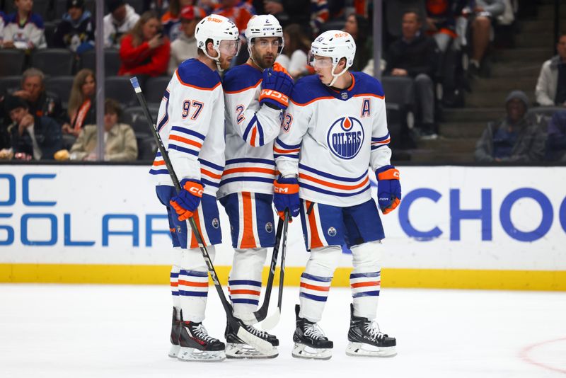 Feb 9, 2024; Anaheim, California, USA; Edmonton Oilers center Connor McDavid (97), defenseman Evan Bouchard, and center Ryan Nugent-Hopkins (93) interact against the Anaheim Ducks during the first period of a game at Honda Center. Mandatory Credit: Jessica Alcheh-USA TODAY Sports