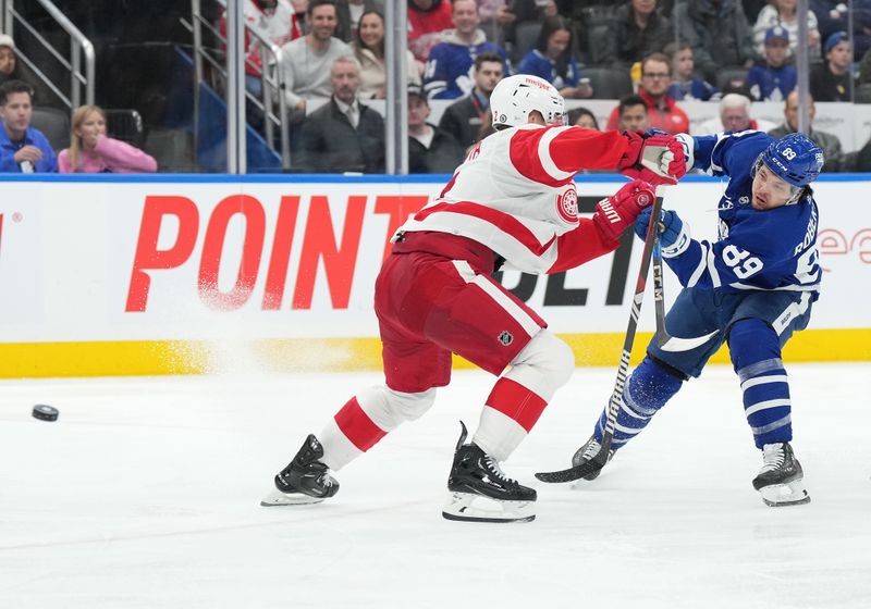 Apr 13, 2024; Toronto, Ontario, CAN; Toronto Maple Leafs left wing Nicholas Robertson (89) shoots the puck past Detroit Red Wings defenseman Olli Maatta (2) during the third period at Scotiabank Arena. Mandatory Credit: Nick Turchiaro-USA TODAY Sports