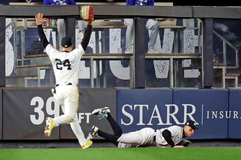 Oct 30, 2024; New York, New York, USA; New York Yankees outfielder Aaron Judge (99) jumps into the outfield wall to catch a fly ball during the fourth inning against the Los Angeles Dodgers in game four of the 2024 MLB World Series at Yankee Stadium. Mandatory Credit: Brad Penner-Imagn Images