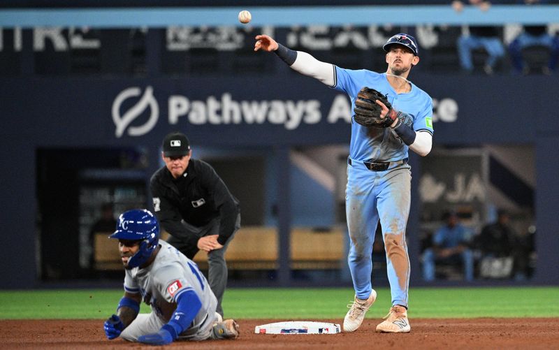 Apr 29, 2024; Toronto, Ontario, CAN; Toronto Blue Jays second baseman Cavan Biggio (8) throws to first but cannot turn a double play after forcing out Kansas City Royals third baseman Maikel Garcia (11) in the ninth inning at Rogers Centre. Mandatory Credit: Dan Hamilton-USA TODAY Sports