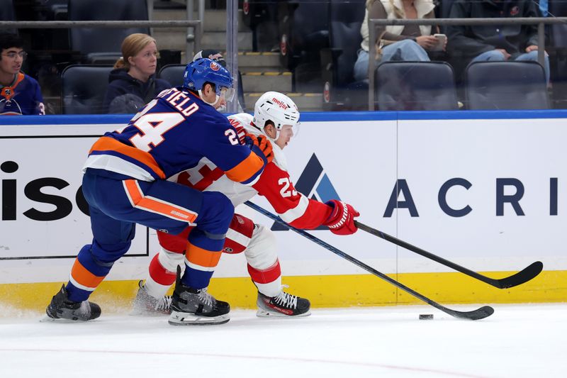 Oct 22, 2024; Elmont, New York, USA; New York Islanders defenseman Scott Mayfield (24) and Detroit Red Wings left wing Lucas Raymond (23) fight for the puck during the first period at UBS Arena. Mandatory Credit: Brad Penner-Imagn Images