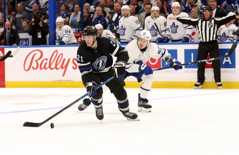 Apr 17, 2024; Tampa, Florida, USA; Tampa Bay Lightning center Brayden Point (21) skates with the puck as Toronto Maple Leafs left wing Tyler Bertuzzi (59) defends during the third period at Amalie Arena. Mandatory Credit: Kim Klement Neitzel-USA TODAY Sports