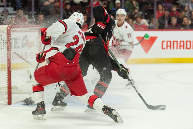 Dec 12, 2023; Ottawa, Ontario, CAN; Carolina Hurricanes center Seth Jarvis (24) scores against Ottawa Senators goalie Joonas Korpisalo (70) in the second period at the Canadian Tire Centre. Mandatory Credit: Marc DesRosiers-USA TODAY Sports