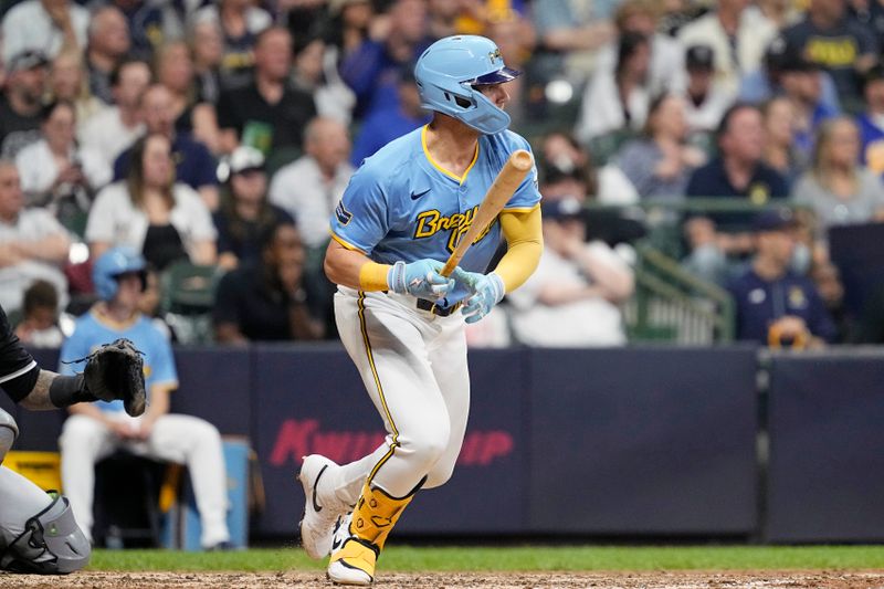 May 31, 2024; Milwaukee, Wisconsin, USA;  Milwaukee Brewers first baseman Jake Bauers (9) hits an RBI single during the seventh inning against the Chicago White Sox at American Family Field. Mandatory Credit: Jeff Hanisch-USA TODAY Sports