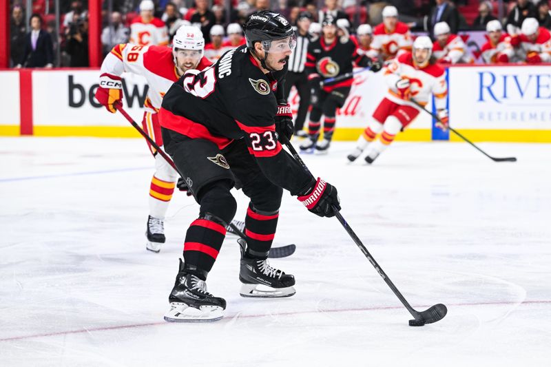 Nov 25, 2024; Ottawa, Ontario, CAN; Ottawa Senators defenseman Travis Hamonic (23) plays the puck against the Calgary Flames during the first period at Canadian Tire Centre. Mandatory Credit: David Kirouac-Imagn Images