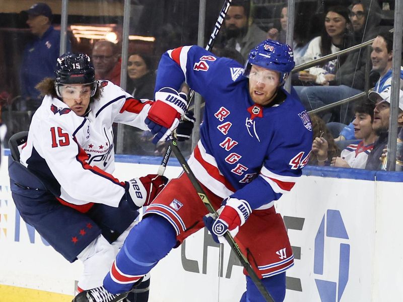 Oct 12, 2025; New York, New York, USA;  Washington Capitals left wing Sonny Milano (15) and New York Rangers defenseman Vladislav Gavrikov (44) battle for control of the puck in the first period at Madison Square Garden. Mandatory Credit: Wendell Cruz-Imagn Images
