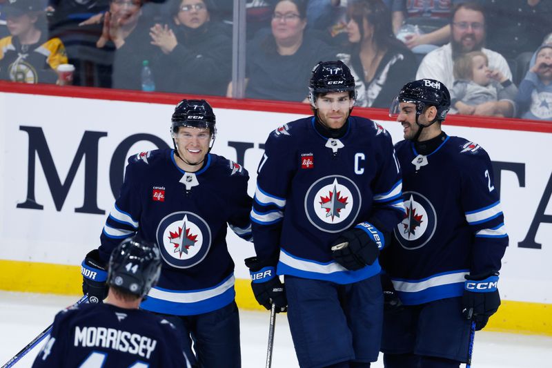 Sep 25, 2024; Winnipeg, Manitoba, CAN; Winnipeg Jets forward Adam Lowry (17) is congratulated by his teammates on his goal against Edmonton Oilers goalie Collin Delia (60) during the third  period at Canada Life Centre. Mandatory Credit: Terrence Lee-Imagn Images