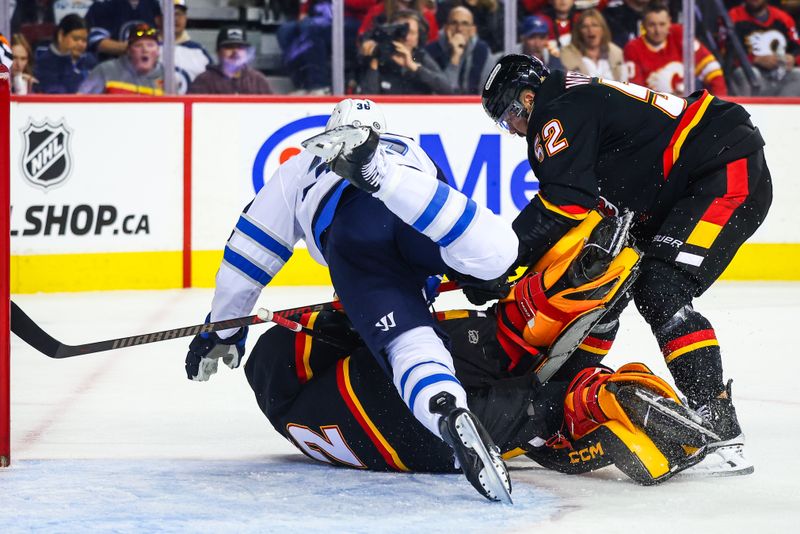 Oct 26, 2024; Calgary, Alberta, CAN; Winnipeg Jets center Morgan Barron (36) and Calgary Flames goaltender Dustin Wolf (32) collides during the first period at Scotiabank Saddledome. Mandatory Credit: Sergei Belski-Imagn Images