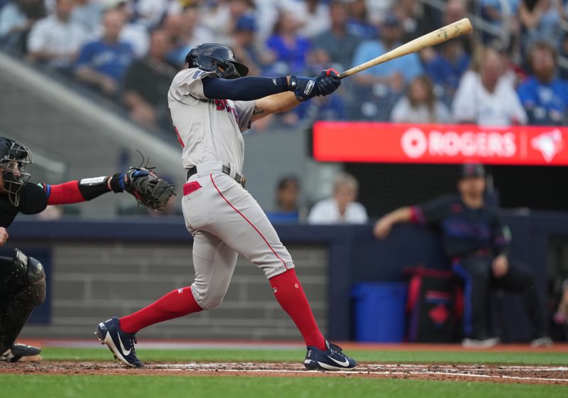 Jun 19, 2024; Toronto, Ontario, CAN; Boston Red Sox right fielder Tyler O'Neill (17) hits an RBI single against the Toronto Blue Jays during the third inning at Rogers Centre. Mandatory Credit: Nick Turchiaro-USA TODAY Sports