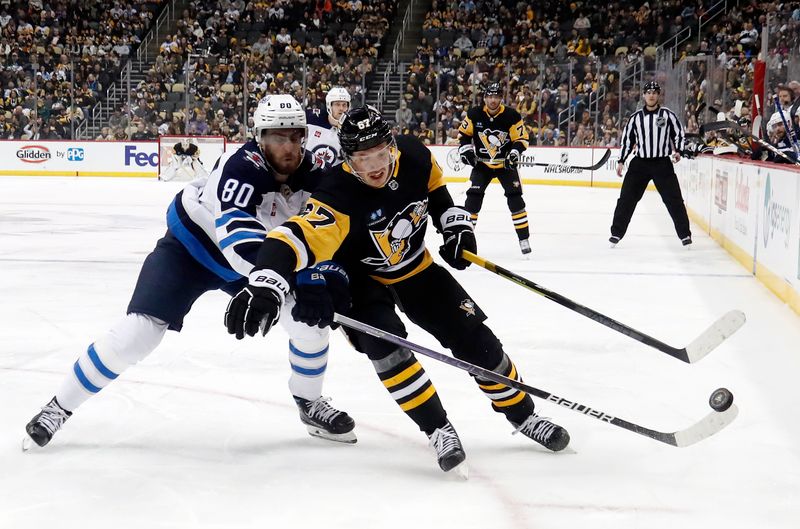 Jan 13, 2023; Pittsburgh, Pennsylvania, USA;  Winnipeg Jets left wing Pierre-Luc Dubois (80) defends against Pittsburgh Penguins right wing Rickard Rakell (67) while chasing the puck during the third period at PPG Paints Arena. The Jets won 4-1. Mandatory Credit: Charles LeClaire-USA TODAY Sports