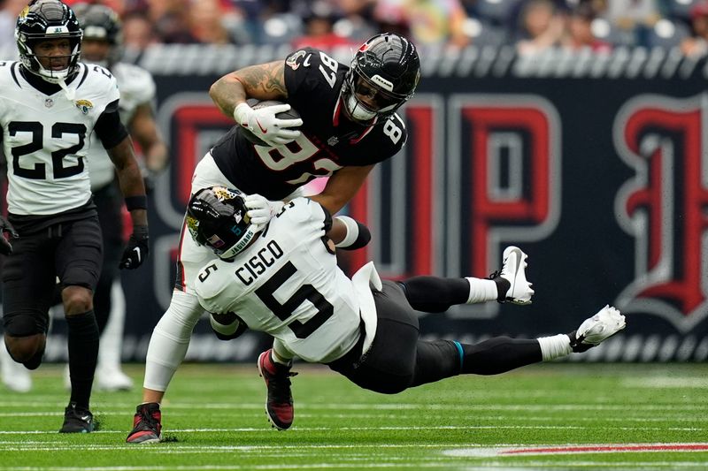 Houston Texans tight end Cade Stover (87) is tackled by Jacksonville Jaguars safety Andre Cisco (5) after catching a pass during the first half of an NFL football game, Sunday, Sept. 29, 2024, in Houston. (AP Photo/Eric Gay)