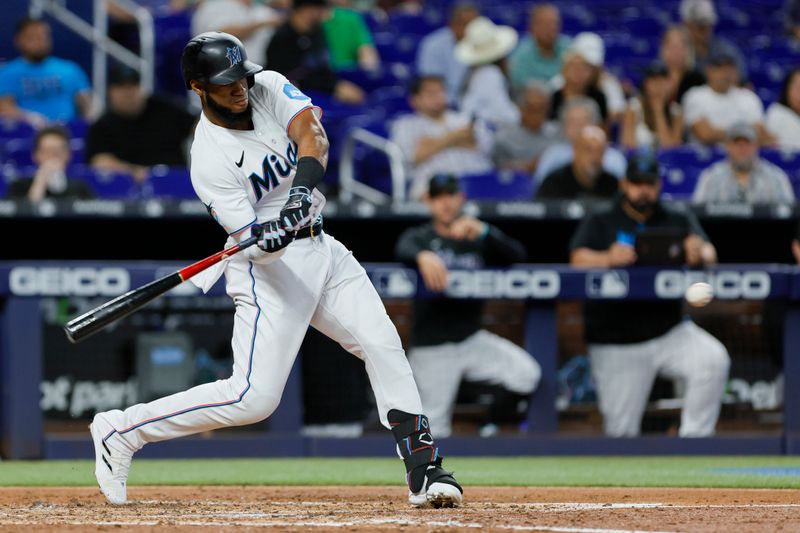 Jun 21, 2023; Miami, Florida, USA; Miami Marlins left fielder Bryan De La Cruz (14) hits a single against the Toronto Blue Jays during the fourth inning at loanDepot Park. Mandatory Credit: Sam Navarro-USA TODAY Sports