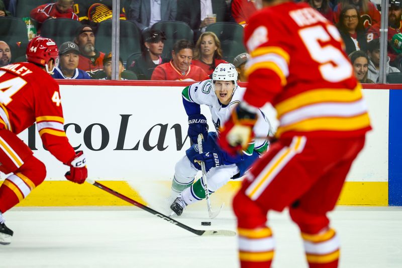 Oct 1, 2025; Calgary, Alberta, CAN; Vancouver Canucks center Aatu Raty (54) controls the puck against the Calgary Flames during the first period at Scotiabank Saddledome. Mandatory Credit: Sergei Belski-Imagn Images