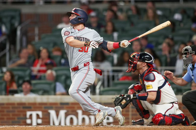 May 30, 2024; Atlanta, Georgia, USA; Washington Nationals center fielder Jacob Young (30) hits a single against the Atlanta Braves in the ninth inning at Truist Park. Mandatory Credit: Brett Davis-USA TODAY Sports