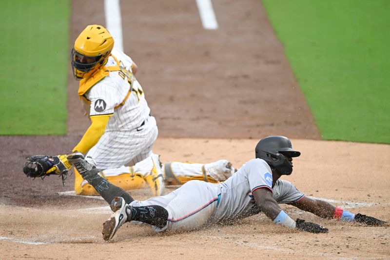 May 27, 2025; San Diego, California, USA; Miami Marlins outfielder Ronny Simon (41) scores ahead of the tag of San Diego Padres catcher Elias Díaz (17) during the first inning at Petco Park. Mandatory Credit: Denis Poroy-Imagn Images