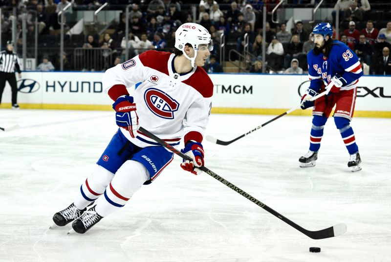 Nov 30, 2024; New York, New York, USA; Montreal Canadiens left wing Juraj Slafkovsky (20) skates with the puck as New York Rangers center Mika Zibanejad (93) trails during the second period at Madison Square Garden. Mandatory Credit: John Jones-Imagn Images