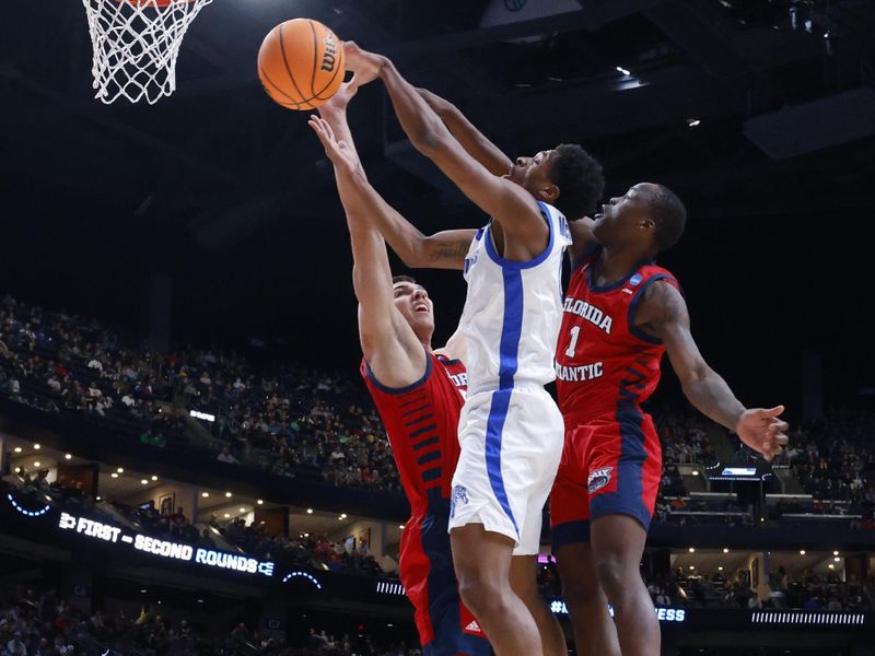 Mar 17, 2023; Columbus, OH, USA; Memphis Tigers guard Elijah McCadden (0) shoots the ball defended by Florida Atlantic Owls center Vladislav Goldin (50) and guard Johnell Davis (1) in the first half at Nationwide Arena. Mandatory Credit: Rick Osentoski-USA TODAY Sports