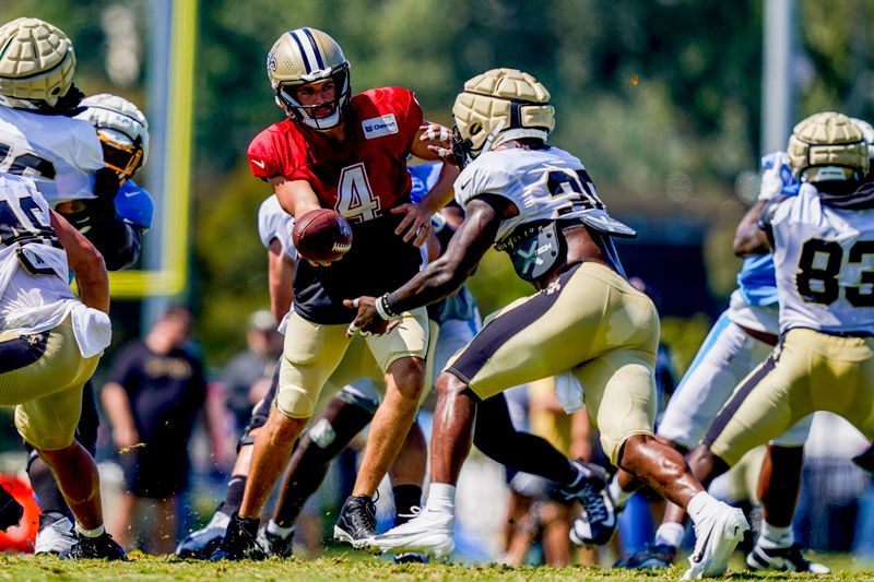 New Orleans Saints quarterback Derek Carr (4) hands off the ball to running back Jamaal Williams (30) during a joint NFL football practice with the Los Angeles Chargers, Thursday, Aug. 17, 2023, in Costa Mesa, Calif. (AP Photo/Ryan Sun)