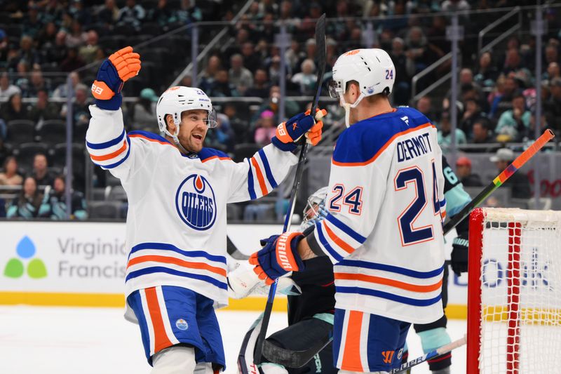 Oct 2, 2024; Seattle, Washington, USA; Edmonton Oilers left wing Viktor Arvidsson (33) and defenseman Travis Dermott (24) celebrate after Dermott scored a goal against the Seattle Kraken during the second period at Climate Pledge Arena. Mandatory Credit: Steven Bisig-Imagn Images