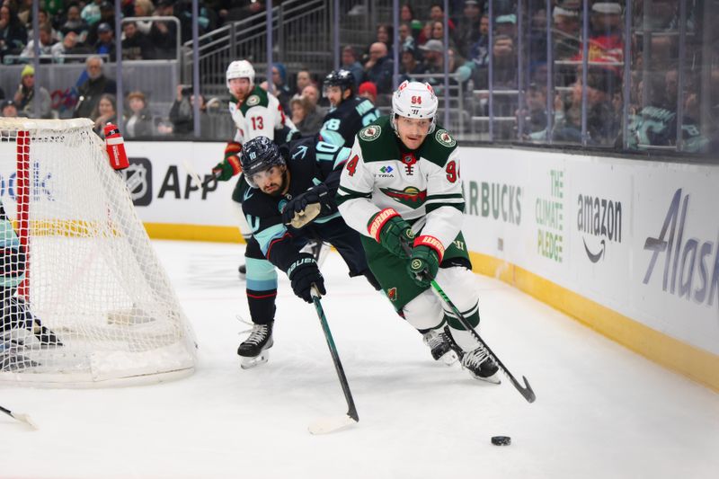 Mar 4, 2025; Seattle, Washington, USA; Minnesota Wild center Jakub Lauko (94) plays the puck while defended by Seattle Kraken center Matty Beniers (10) during the second period at Climate Pledge Arena. Mandatory Credit: Steven Bisig-Imagn Images