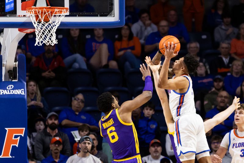 Feb 13, 2024; Gainesville, Florida, USA; Florida Gators guard Will Richard (5) attempts a layup over LSU Tigers forward Will Baker (9) and LSU Tigers guard Jordan Wright (6) during the first half at Exactech Arena at the Stephen C. O'Connell Center. Mandatory Credit: Matt Pendleton-USA TODAY Sports