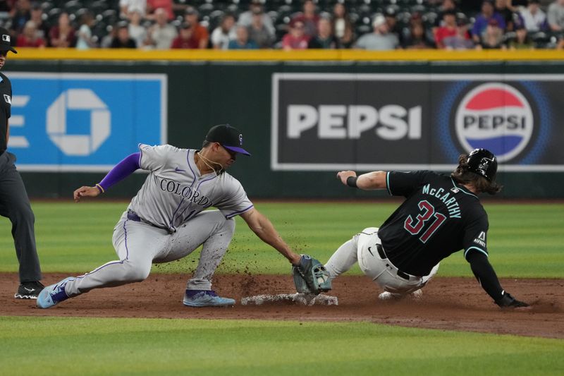 Aug 12, 2024; Phoenix, Arizona, USA; Arizona Diamondbacks outfielder Jake McCarthy (31) steals second base under the tag by Colorado Rockies shortstop Ezequiel Tovar (14) in the sixth inning at Chase Field. Mandatory Credit: Rick Scuteri-USA TODAY Sports