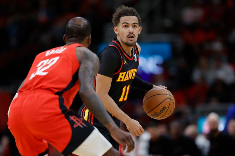 HOUSTON, TEXAS - DECEMBER 20: Trae Young #11 of the Atlanta Hawks controls the ball ahead of Jeff Green #32 of the Houston Rockets during the first half at Toyota Center on December 20, 2023 in Houston, Texas. User expressly acknowledges and agrees that, by downloading and or using this photograph, User is consenting to the terms and conditions of the Getty Images License Agreement.?  (Photo by Carmen Mandato/Getty Images)