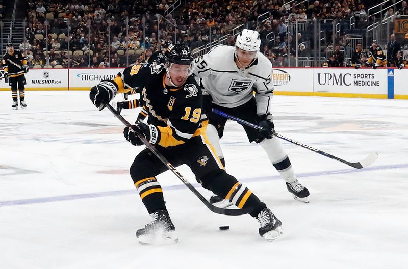 Feb 18, 2024; Pittsburgh, Pennsylvania, USA;  Pittsburgh Penguins right wing Reilly Smith (19) handles the puck against  Los Angeles Kings defenseman Quentin Byfield (55) during the third period at PPG Paints Arena.  Los Angeles won 2-1.Mandatory Credit: Charles LeClaire-USA TODAY Sports