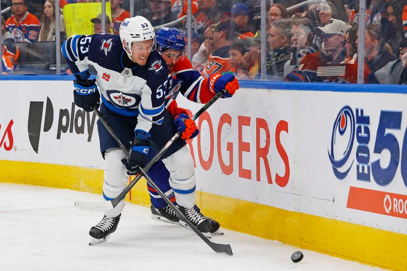 Sep 26, 2025; Edmonton, Alberta, CAN; Winnipeg Jets forward Danil Zhilkin (53) and Edmonton Oilers Forward Matt Savoie (22) battle along the boards for a loose puck  during the third period at Rogers Place. Mandatory Credit: Perry Nelson-Imagn Images