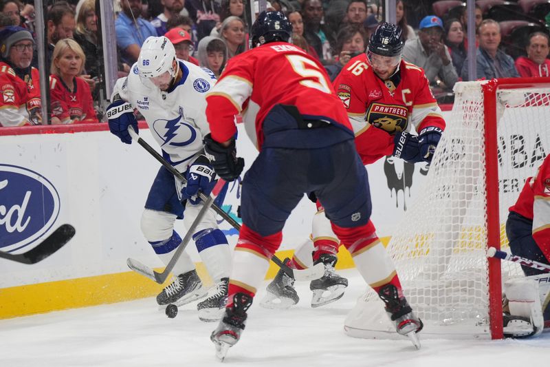 Sep 30, 2024; Sunrise, Florida, USA;  ampa Bay Lightning right wing Nikita Kucherov (86) battles for possession as Florida Panthers defenseman Aaron Ekblad (5) closes in during the first period at Amerant Bank Arena. Mandatory Credit: Jim Rassol-Imagn Images