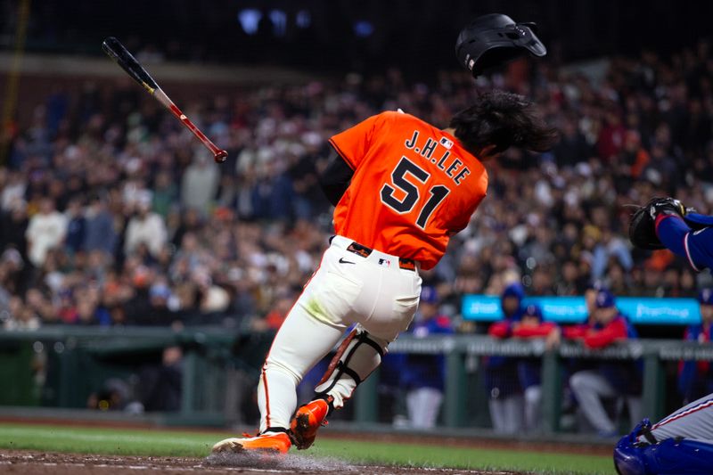 Apr 25, 2025; San Francisco, California, USA; San Francisco Giants center fielder Jung Hoo Lee (51) ducks out of the way of a high and tight pitch from Texas Rangers pitcher Robert Garcia (62) during the ninth inning at Oracle Park. Umpires ruled that Lee was hit by the 2-2 pitch, but that he also offered at it, and thus was out. Mandatory Credit: D. Ross Cameron-Imagn Images