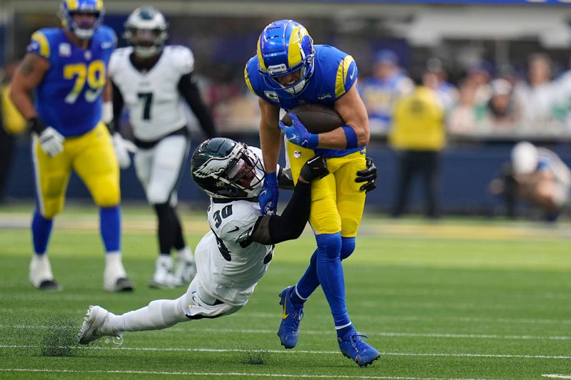 Los Angeles Rams wide receiver Cooper Kupp, right, is dragged down by Philadelphia Eagles safety Justin Evans during the first half of an NFL football game Sunday, Oct. 8, 2023, in Inglewood, Calif. (AP Photo/Gregory Bull)