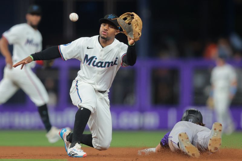 Jun 3, 2025; Miami, Florida, USA; Colorado Rockies third baseman Jordan Beck (27) steals second base against Miami Marlins shortstop Xavier Edwards (9) during the fifth inning at loanDepot Park. Mandatory Credit: Sam Navarro-Imagn Images