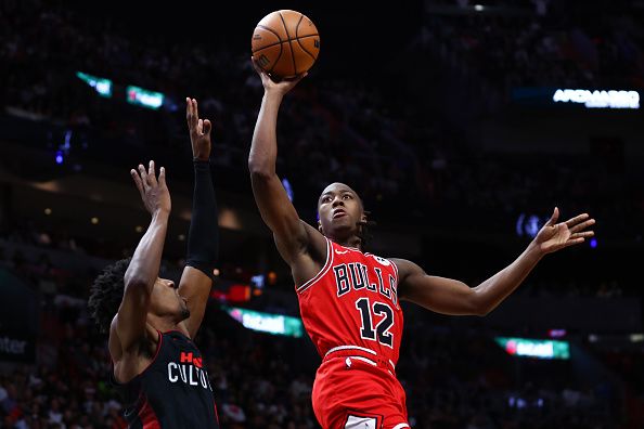 MIAMI, FLORIDA - DECEMBER 16: Ayo Dosunmu #12 of the Chicago Bulls shoots the ball over Josh Richardson #0 of the Miami Heat during the fourth quarter of the game at Kaseya Center on December 16, 2023 in Miami, Florida. NOTE TO USER: User expressly acknowledges and agrees that, by downloading and or using this photograph, User is consenting to the terms and conditions of the Getty Images License Agreement. (Photo by Megan Briggs/Getty Images)