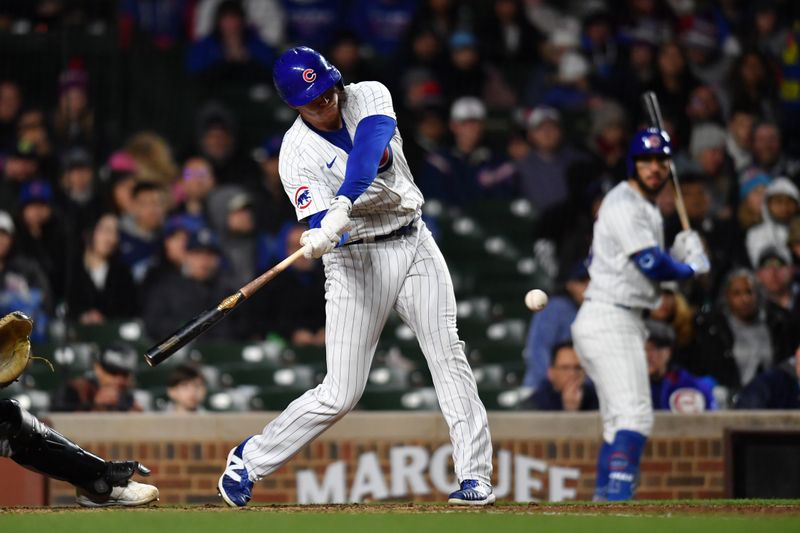 Apr 20, 2024; Chicago, Illinois, USA; Chicago Cubs first baseman Garrett Cooper (41) hits a single RBI during the sixth inning against the Miami Marlins at Wrigley Field. Mandatory Credit: Patrick Gorski-USA TODAY Sports