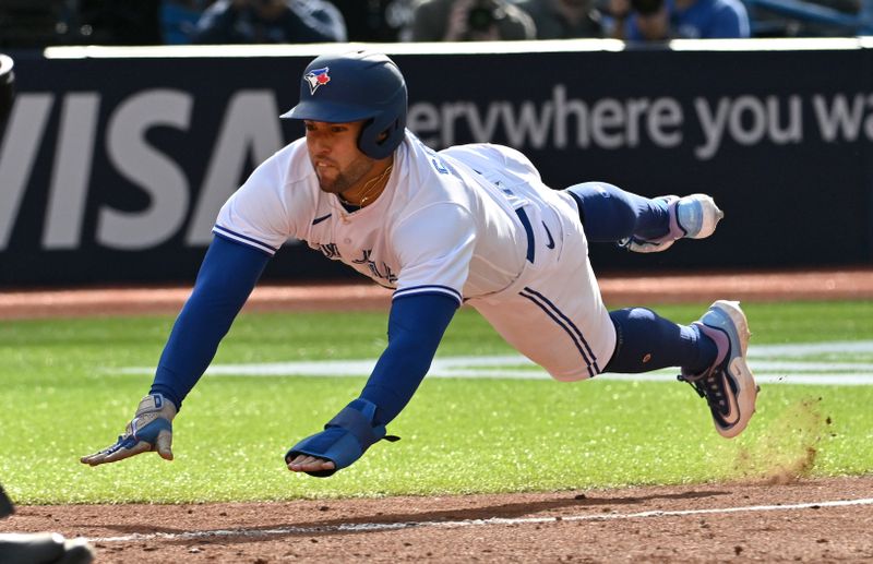 May 13, 2023; Toronto, Ontario, CAN; Toronto Blue Jays right fielder George Springer (4) dives toward home plate as he scores a run against the Atlanta Braves in the seventh inning at Rogers Centre. Mandatory Credit: Dan Hamilton-USA TODAY Sports