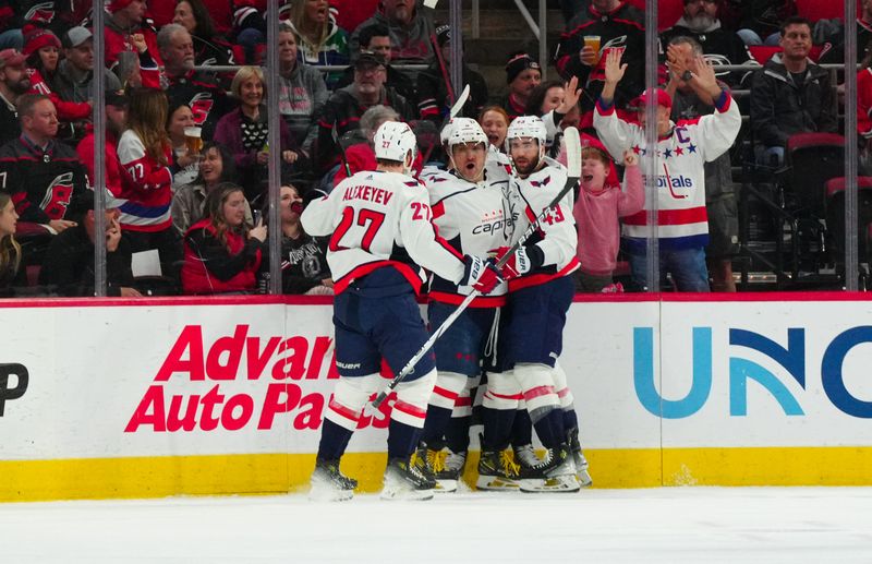 Apr 5, 2024; Raleigh, North Carolina, USA; Washington Capitals left wing Alex Ovechkin (8) is congratulated by right wing Tom Wilson (43) and defenseman Alexander Alexeyev (27) against the Carolina Hurricanes during the first period at PNC Arena. Mandatory Credit: James Guillory-USA TODAY Sports