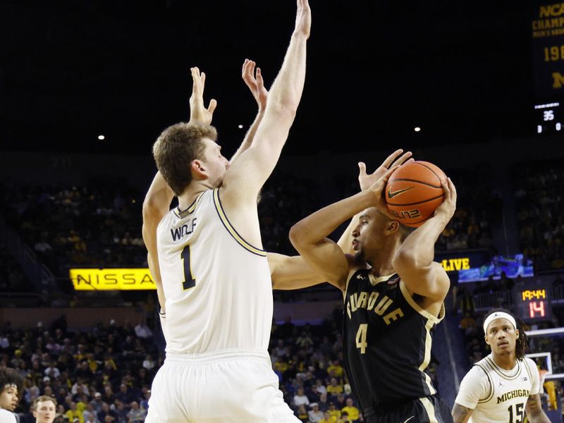 Feb 11, 2025; Ann Arbor, Michigan, USA;  Purdue Boilermakers forward Trey Kaufman-Renn (4) is defended by Michigan Wolverines center Danny Wolf (1) in the second half at Crisler Center. Mandatory Credit: Rick Osentoski-Imagn Images