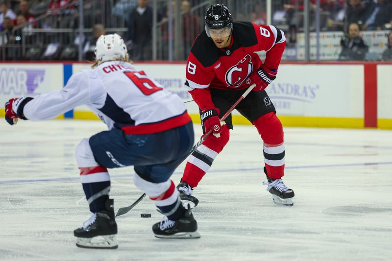 Nov 30, 2024; Newark, New Jersey, USA; New Jersey Devils defenseman Johnathan Kovacevic (8) skates with the puck while Washington Capitals defenseman Jakob Chychrun (6) defends during the second period at Prudential Center. Mandatory Credit: Thomas Salus-Imagn Images