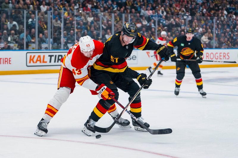 Oct 9, 2025; Vancouver, British Columbia, CAN; Calgary Flames forward Adam Klapka (43) battles with Vancouver Canucks defenseman Tyler Myers (57) in the first period at Rogers Arena. Mandatory Credit: Bob Frid-Imagn Images