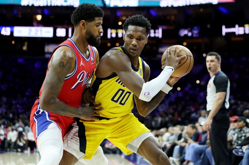 PHILADELPHIA, PENNSYLVANIA - DECEMBER 13: Bennedict Mathurin #00 of the Indiana Pacers drives against Paul George #8 of the Philadelphia 76ers during the first half at the Wells Fargo Center on December 13, 2024 in Philadelphia, Pennsylvania. NOTE TO USER: User expressly acknowledges and agrees that, by downloading and or using this photograph, User is consenting to the terms and conditions of the Getty Images License Agreement. (Photo by Emilee Chinn/Getty Images)