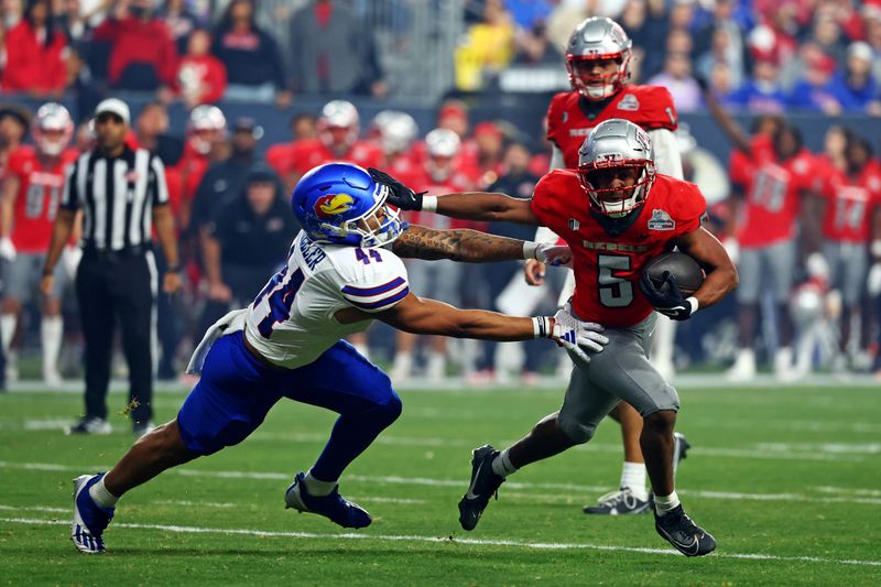 Dec 26, 2023; Phoenix, AZ, USA; UNLV Rebels running back Vincent Davis Jr. (5) runs the ball against Kansas Jayhawks linebacker Cornell Wheeler (44) during the second half in the Guaranteed Rate Bowl at Chase Field. Mandatory Credit: Mark J. Rebilas-USA TODAY Sports