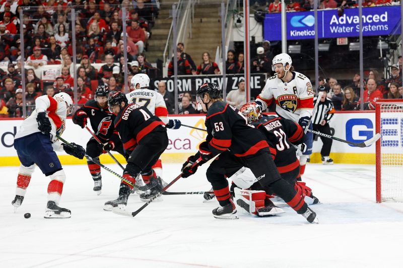 May 28, 2025; Raleigh, North Carolina, USA; Florida Panthers forward Sam Bennett (9) battles for the puck against Carolina Hurricanes defenseman Shayne Gostibehere (4) in front of goaltender Frederik Andersen (31) during the first period in game five of the Eastern Conference Final of the 2025 Stanley Cup Playoffs at Lenovo Center. Mandatory Credit: Geoff Burke-Imagn Images