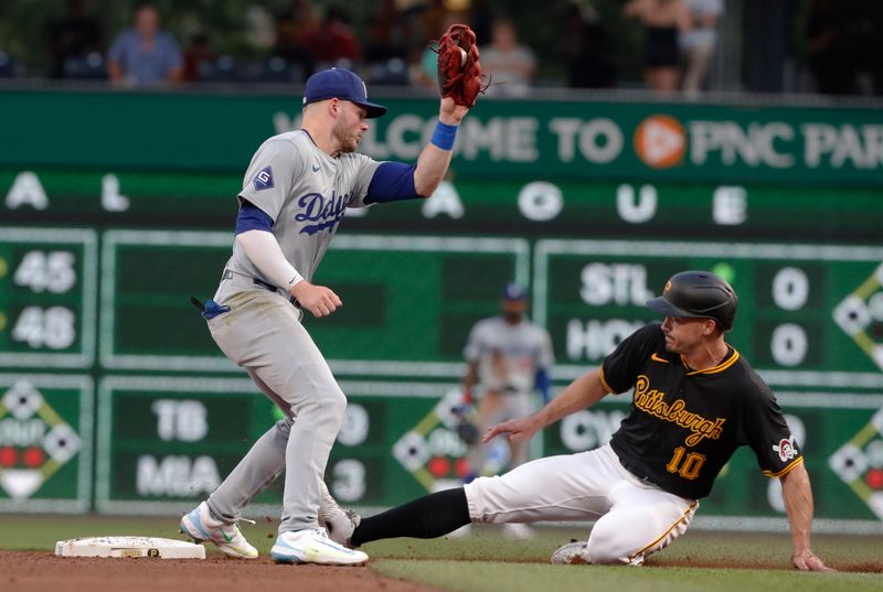 Jun 4, 2024; Pittsburgh, Pennsylvania, USA;  Pittsburgh Pirates left fielder Bryan Reynolds (10) steals second base as Los Angeles Dodgers second baseman Gavin Lux (9) takes a high throw during the sixth inning at PNC Park. Mandatory Credit: Charles LeClaire-USA TODAY Sports